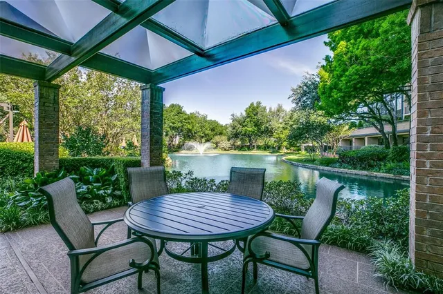 a view of a patio with table and chairs under an umbrella
