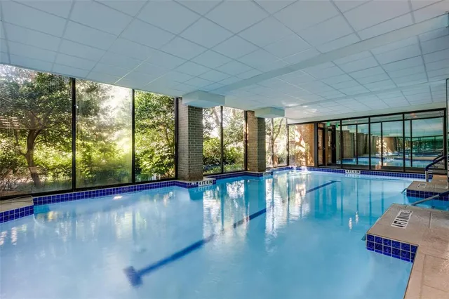 a view of an empty room with wooden floor and a floor to ceiling window