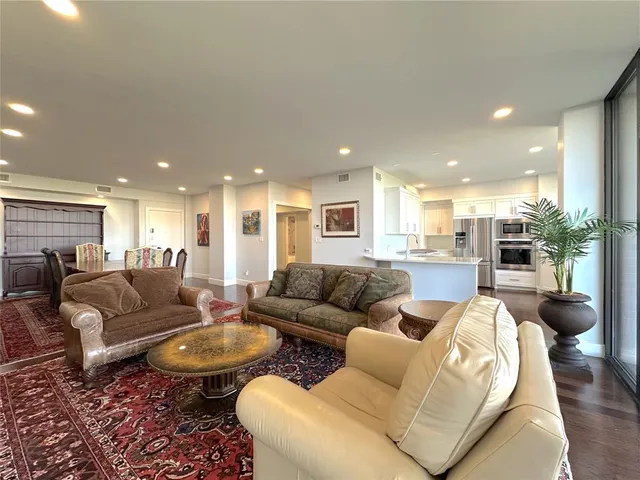 a living room with furniture and a view of kitchen
