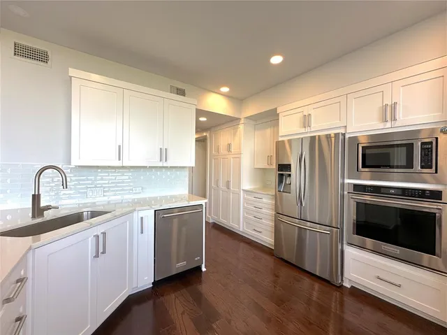 a kitchen with stainless steel appliances a refrigerator sink and microwave