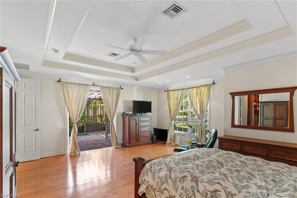 8840 Mariposa Court Naples, FL 34113 - Photo 11 of 50 a bedroom with a bed and a large window with the outer view