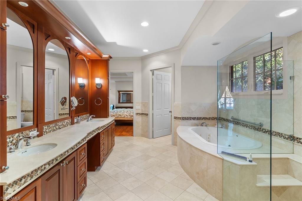 8840 Mariposa Court Naples, FL 34113 - Photo 13 of 50 a spacious bathroom with a bathtub and a sink