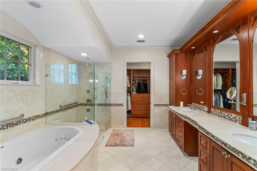 8840 Mariposa Court Naples, FL 34113 - Photo 15 of 50 a large bathroom with a tub sink shower and mirror