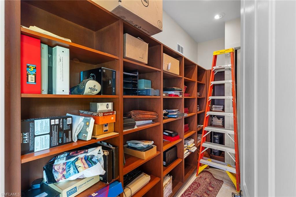 8840 Mariposa Court Naples, FL 34113 - Photo 21 of 50 a living room with lots of books and a baby crib