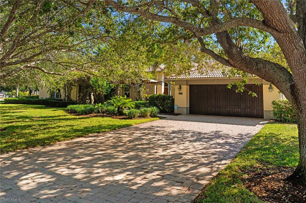 8840 Mariposa Court Naples, FL 34113 - Photo 23 of 50 a front view of a house with a yard and garage