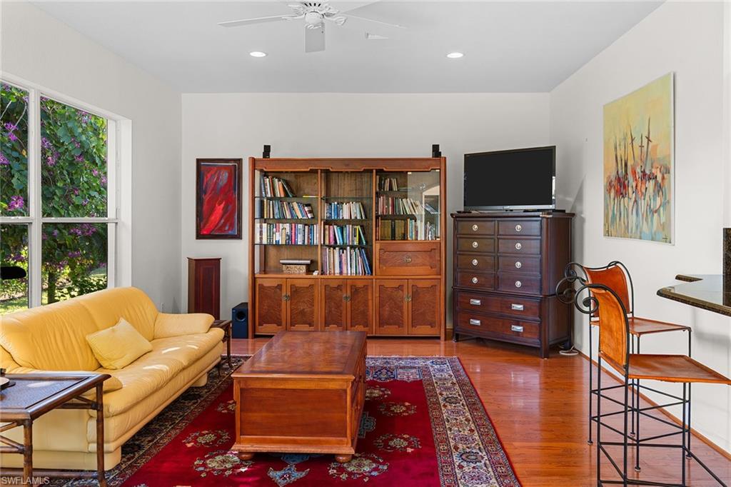 8840 Mariposa Court Naples, FL 34113 - Photo 30 of 50 a living room with furniture and a flat screen tv
