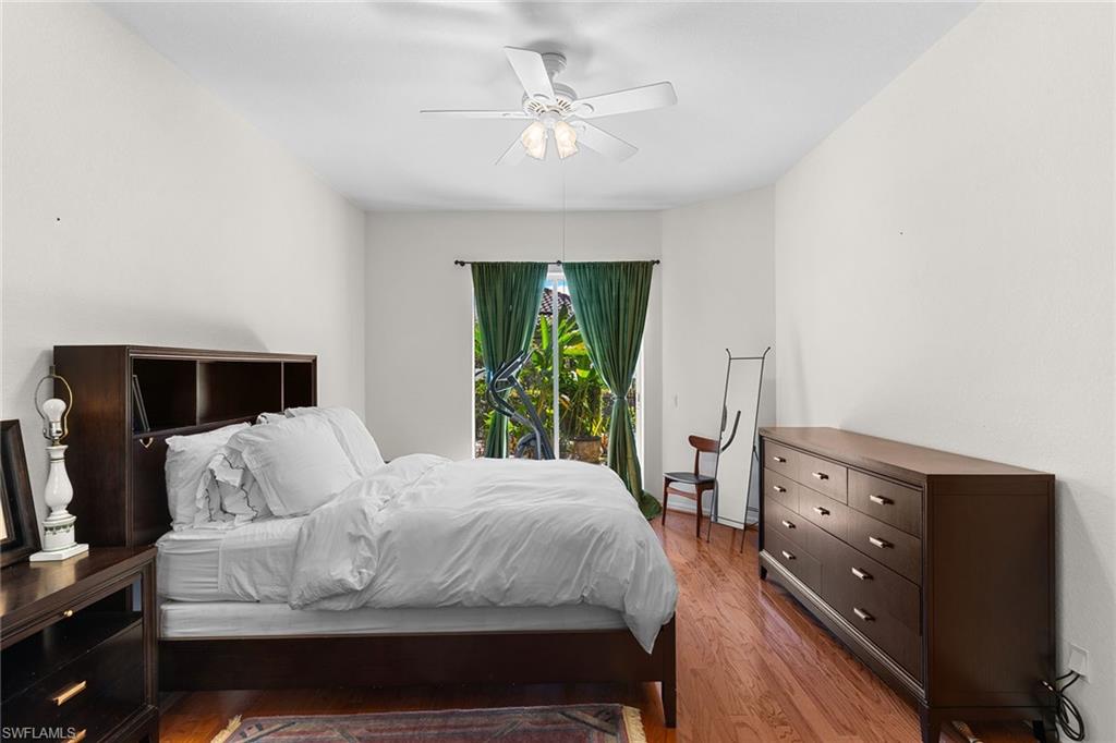 8840 Mariposa Court Naples, FL 34113 - Photo 41 of 50 a bedroom with a bed and a chandelier