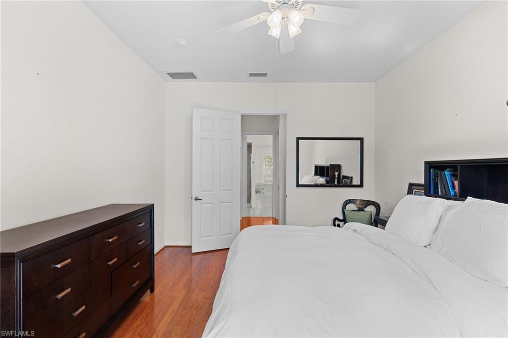 8840 Mariposa Court Naples, FL 34113 - Photo 42 of 50 a bedroom with a bed and a chandelier