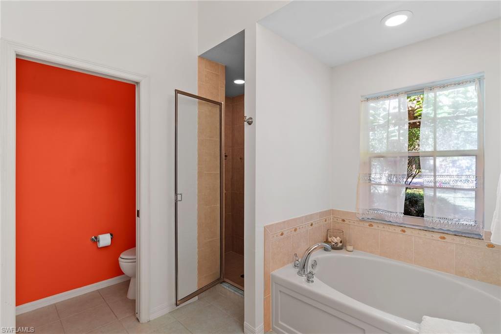 8840 Mariposa Court Naples, FL 34113 - Photo 44 of 50 a bathroom with a bathtub and a shower