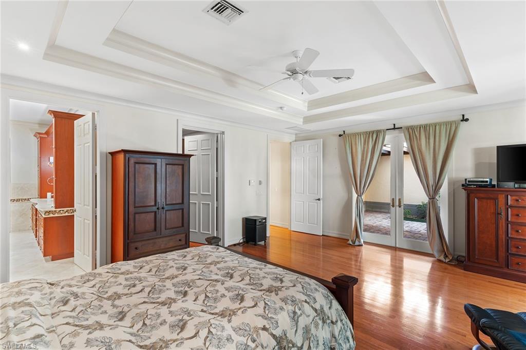 8840 Mariposa Court Naples, FL 34113 - Photo 9 of 50 a bedroom with a bed and wooden floor