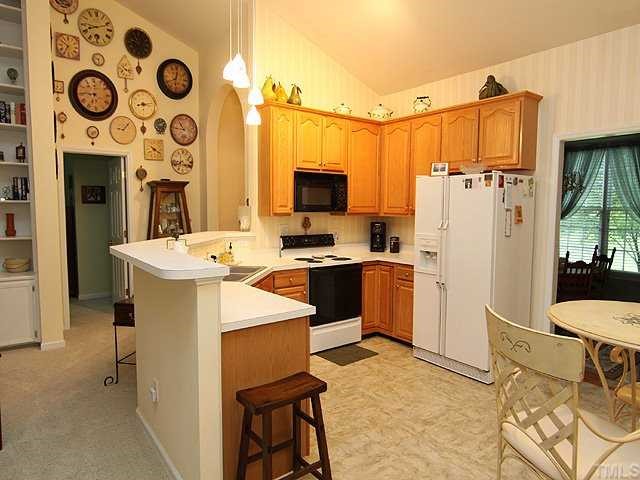 10713 Durant Road Raleigh, NC 27615 - Photo 4 of 12 a kitchen with stainless steel appliances a refrigerator and a stove top oven