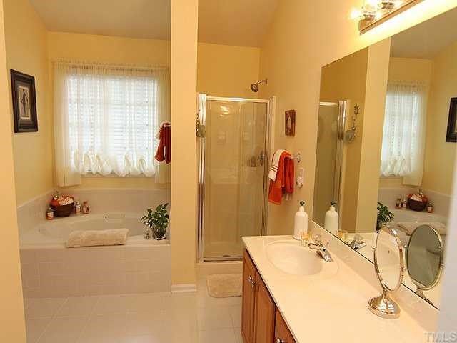 10713 Durant Road Raleigh, NC 27615 - Photo 7 of 12 a bathroom with a tub sink and mirror