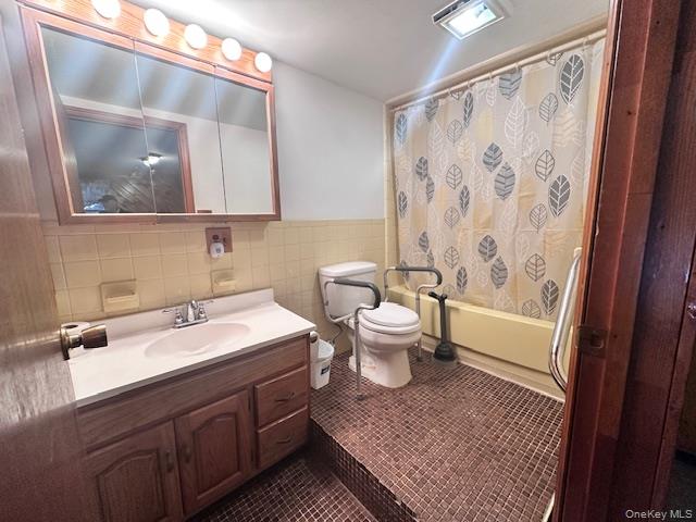 64 Yankee Lake Road Wurtsboro, NY 12790 - Photo 3 of 5 Bathroom featuring tile walls, vanity, shower / tub combo, and dark tile patterned flooring