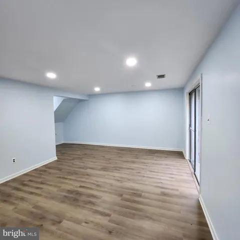 a view of an empty room with wooden floor