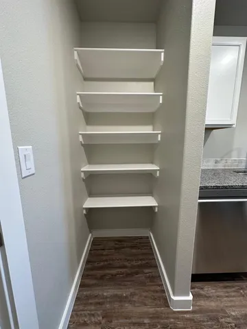 a view of a hallway with wooden floor and a sink