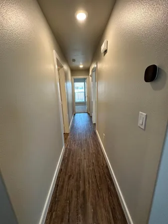 a view of a hallway with wooden floor