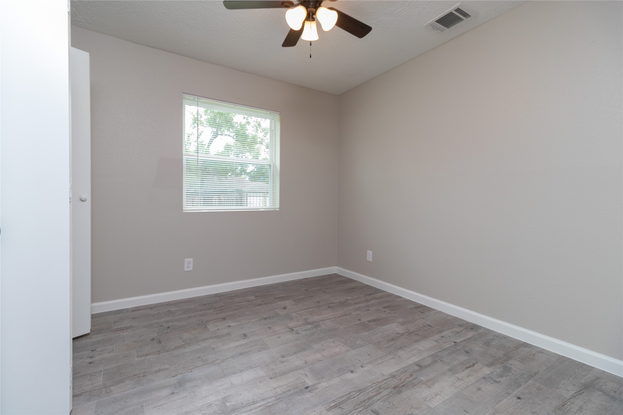 9603 Seeker Street Houston, TX 77078 - Photo 12 of 21 an empty room with a window and a chandelier fan