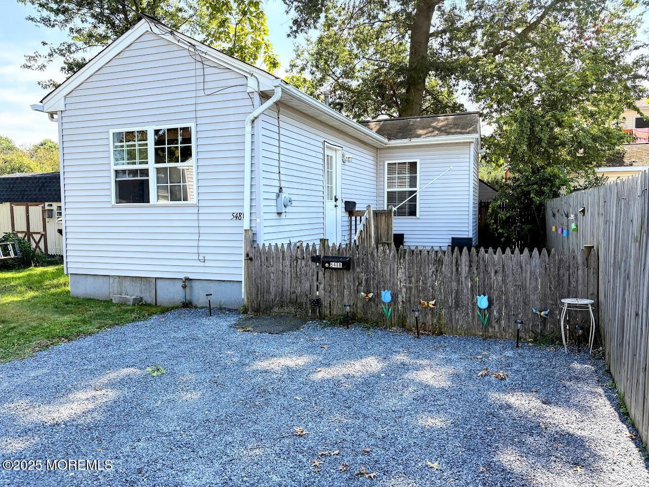 a view of a house with a yard and a large tree