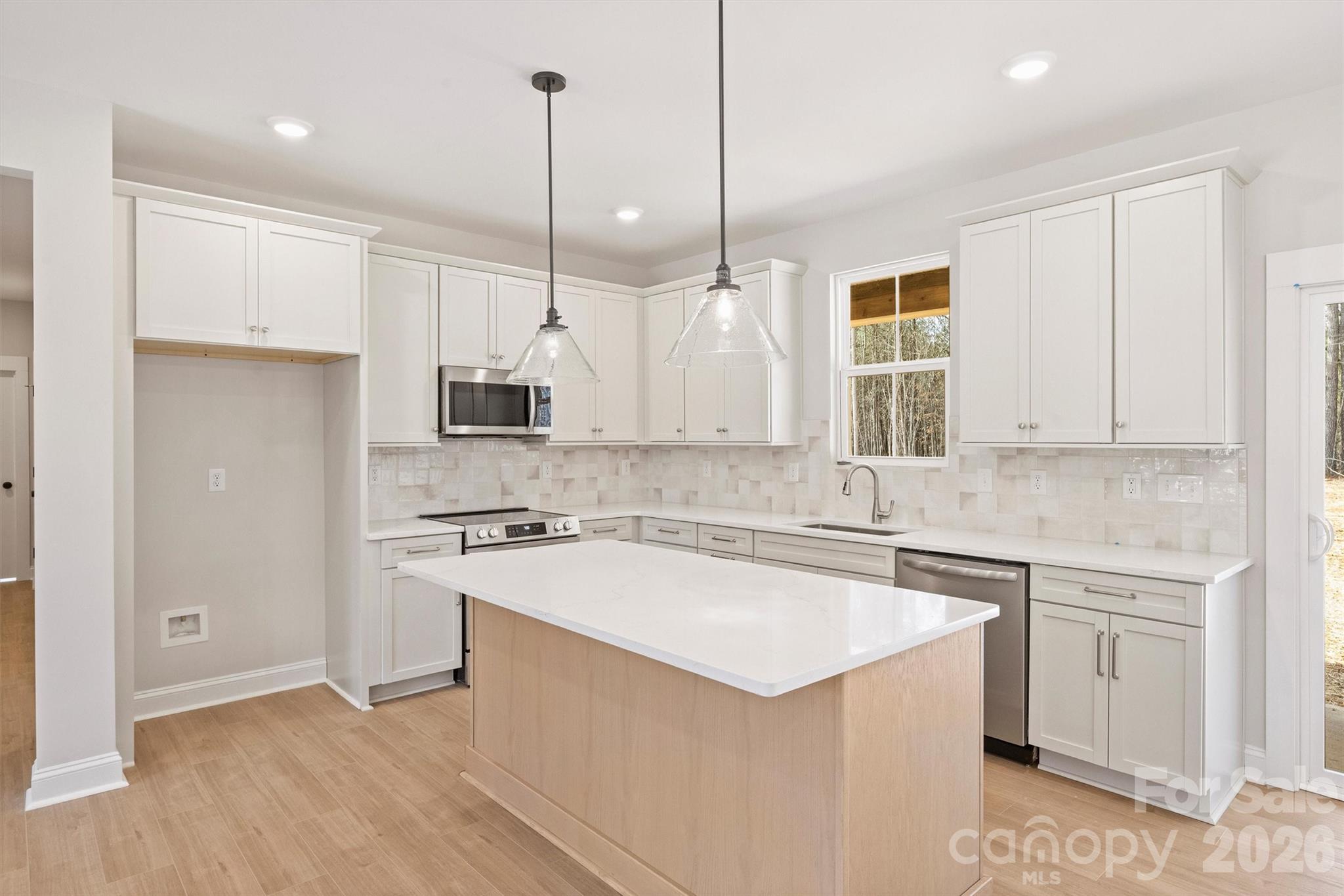 2279 Lee Lawing Road Lincolnton, NC 28092 - Photo 11 of 41 a kitchen with a sink a stove a refrigerator and white cabinets