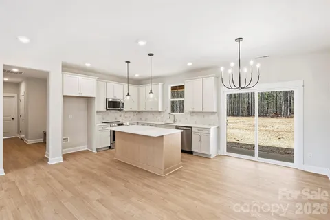 a large kitchen with granite countertop a white stove top oven and cabinets