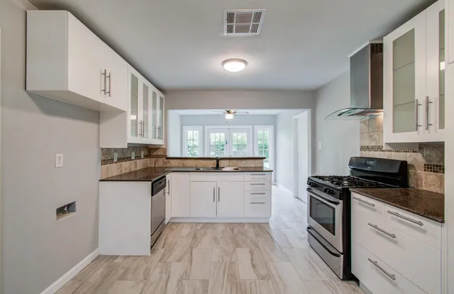 a kitchen with white cabinets and appliances