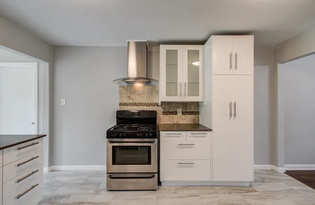 a kitchen with granite countertop a stove and a refrigerator