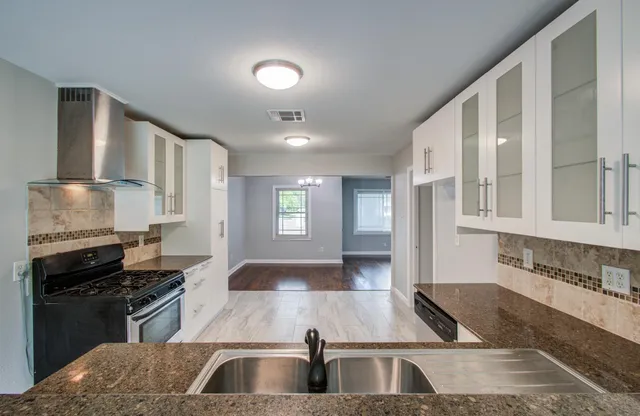 a kitchen with stainless steel appliances granite countertop a sink and a stove