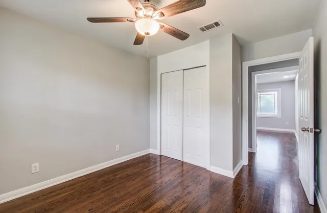 a view of an empty room with wooden floor
