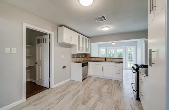a kitchen with a refrigerator and white cabinets