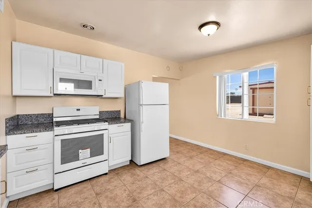 a kitchen with cabinets appliances and a window
