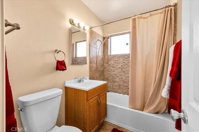 a bathroom with a sink a toilet a mirror a vanity and shower