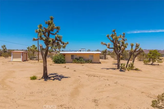 a view of a dirt road with a building in the background