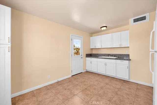 a kitchen with granite countertop white cabinets and white appliances