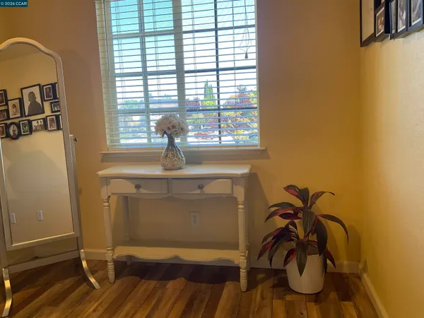 a view of a room that has a window and a wooden floor