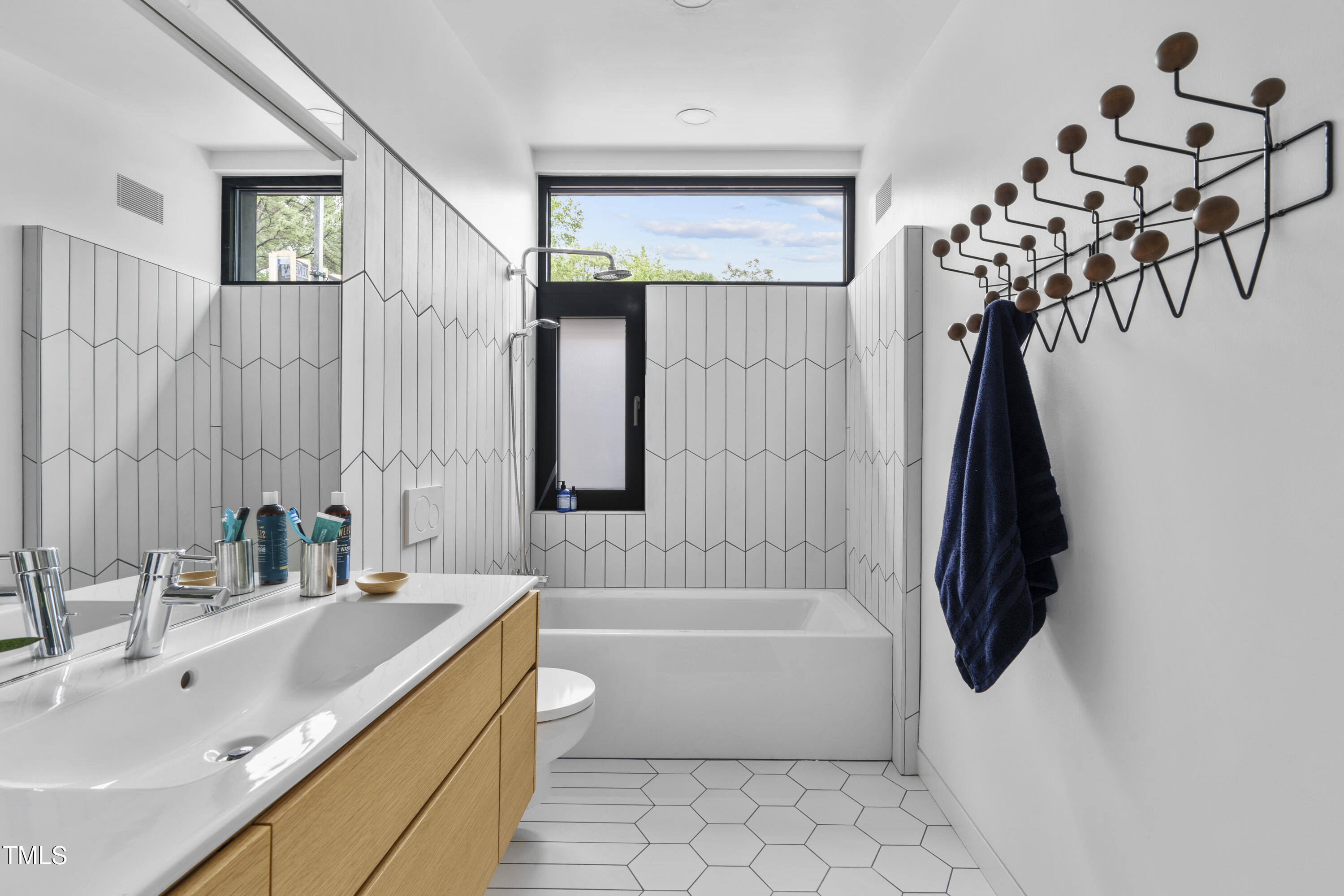 922 Tower Street Raleigh, NC 27607 - Photo 31 of 48 a bathroom with a tub sink and mirror
