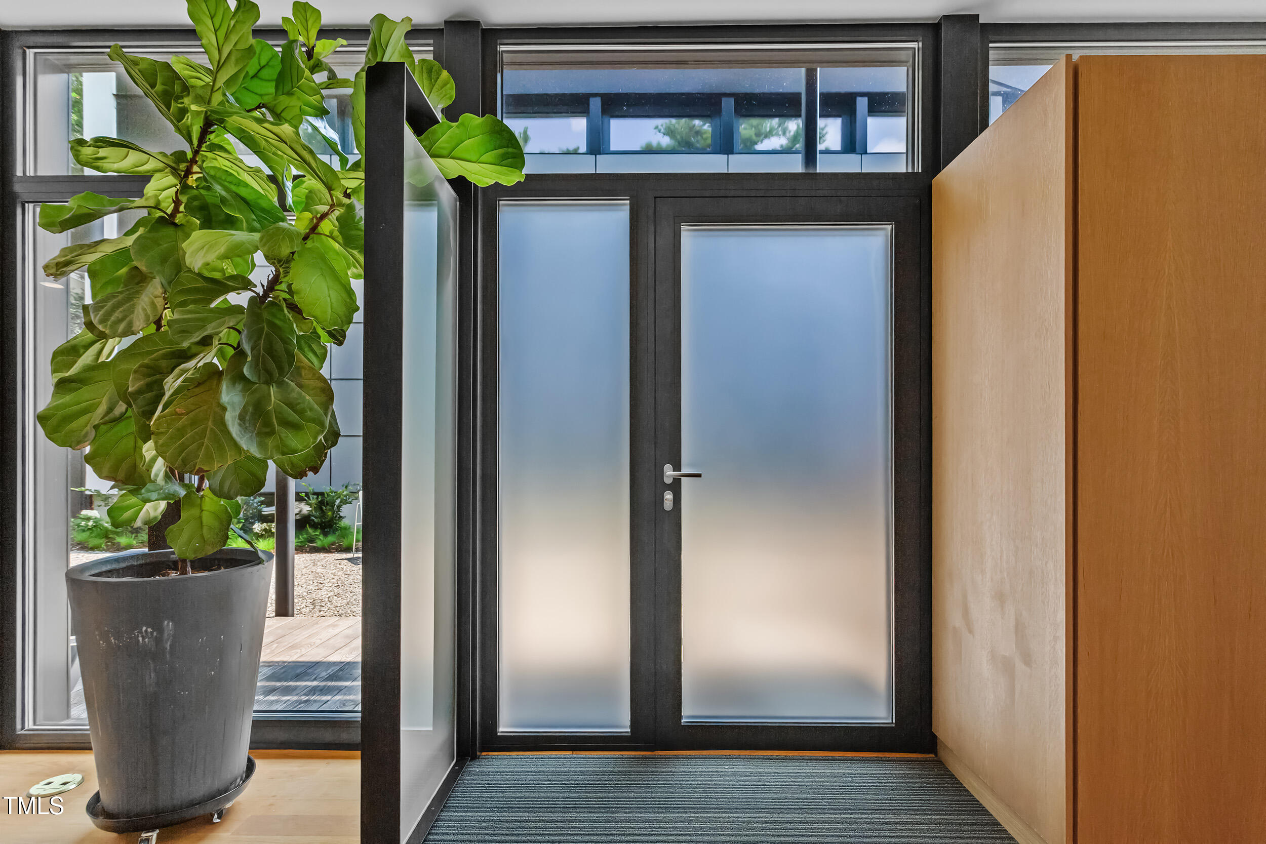 922 Tower Street Raleigh, NC 27607 - Photo 6 of 48 a glass door with a plant in it