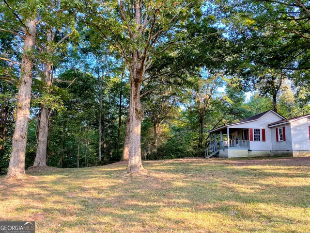 a view of house with outdoor space and trees around