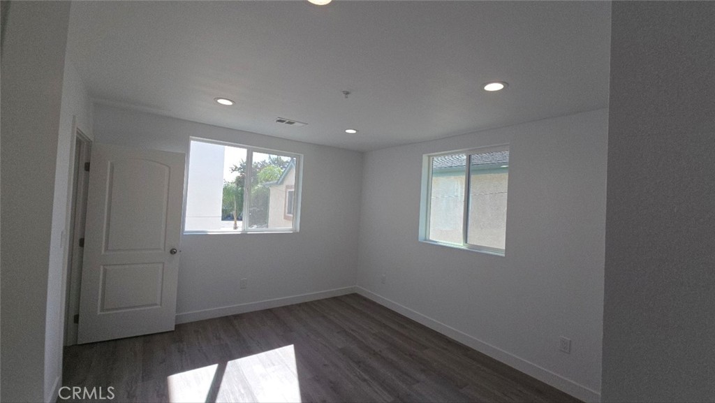 10415 South Avalon Boulevard Los Angeles, CA 90003 - Photo 13 of 40 an empty room with wooden floor and windows