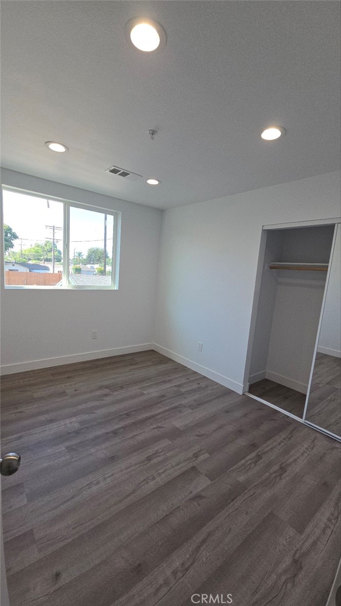 10415 South Avalon Boulevard Los Angeles, CA 90003 - Photo 20 of 40 an empty room with wooden floor and windows