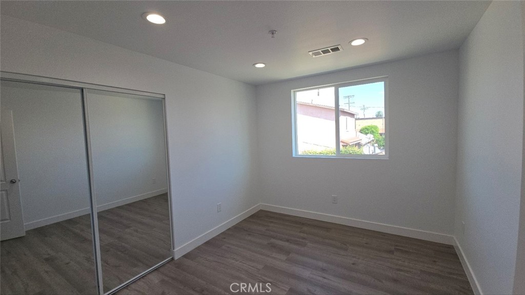 10415 South Avalon Boulevard Los Angeles, CA 90003 - Photo 26 of 40 a view of an empty room with wooden floor and a window