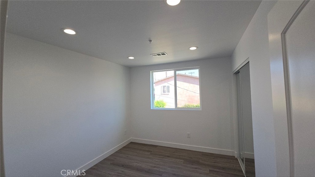 10415 South Avalon Boulevard Los Angeles, CA 90003 - Photo 28 of 40 a view of an empty room with wooden floor and a window