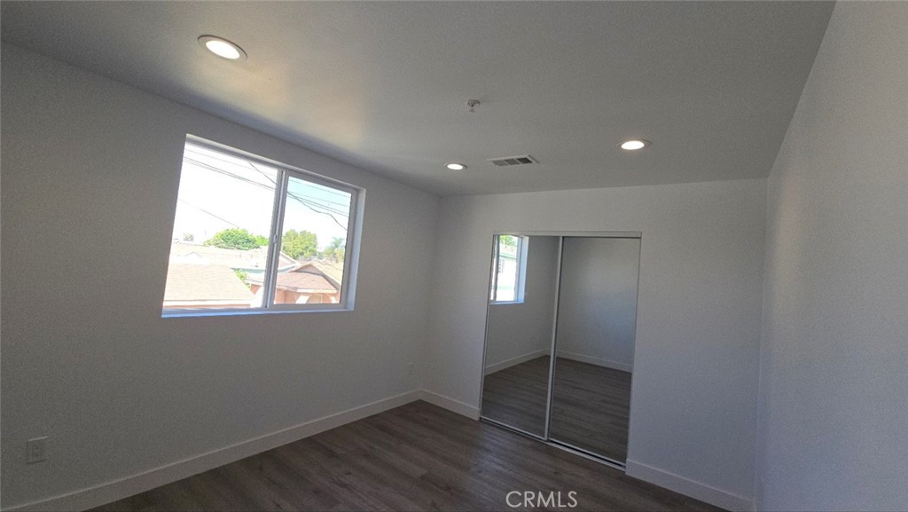 10415 South Avalon Boulevard Los Angeles, CA 90003 - Photo 29 of 40 an empty room with wooden floor and windows