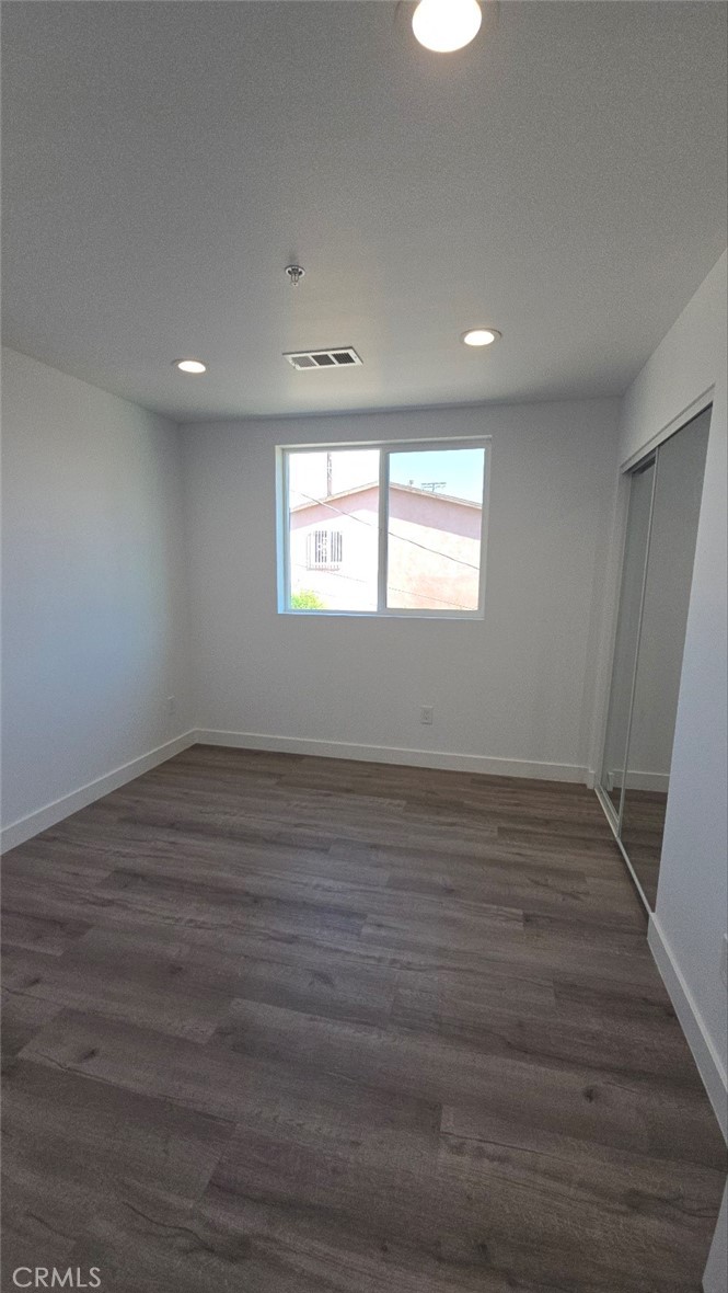 10415 South Avalon Boulevard Los Angeles, CA 90003 - Photo 32 of 40 an empty room with wooden floor and windows
