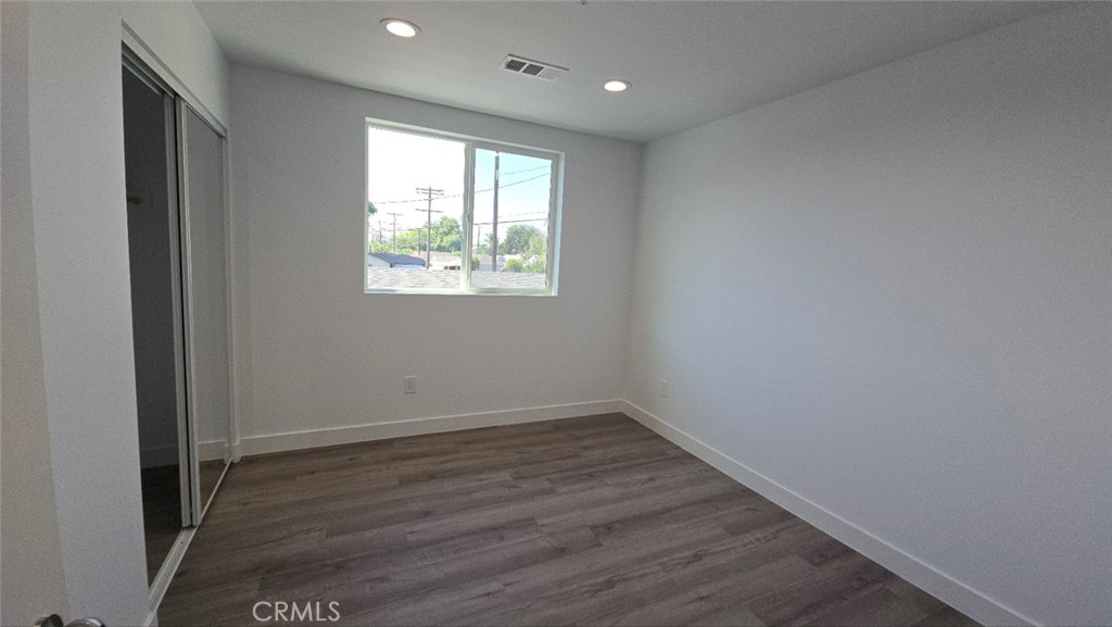 10415 South Avalon Boulevard Los Angeles, CA 90003 - Photo 38 of 40 an empty room with wooden floor and windows