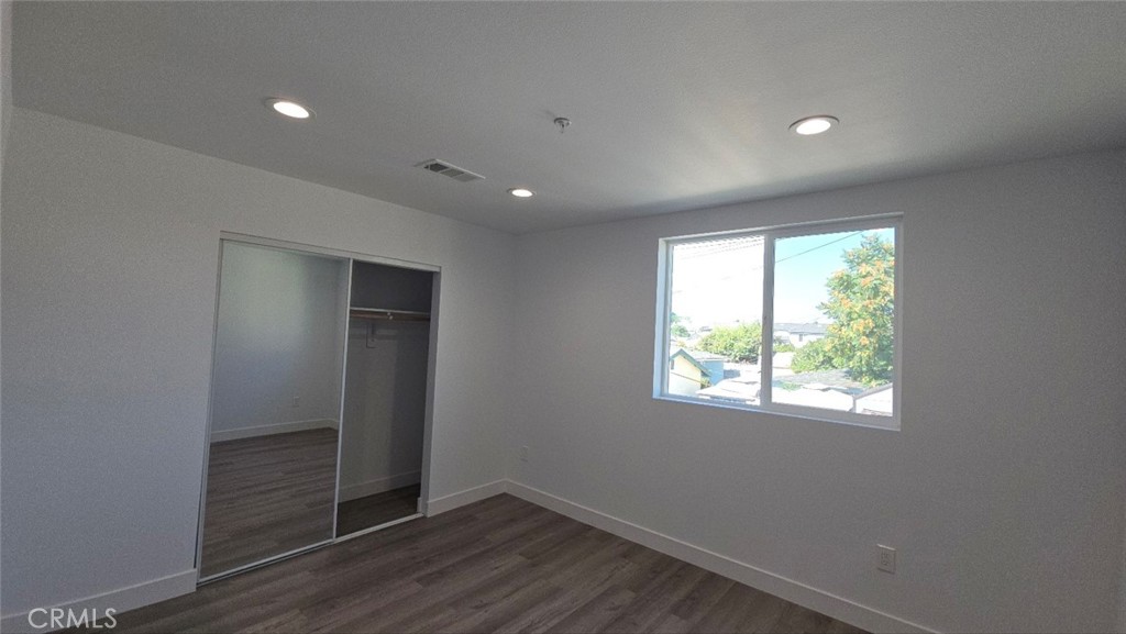 10415 South Avalon Boulevard Los Angeles, CA 90003 - Photo 39 of 40 an empty room with wooden floor and windows