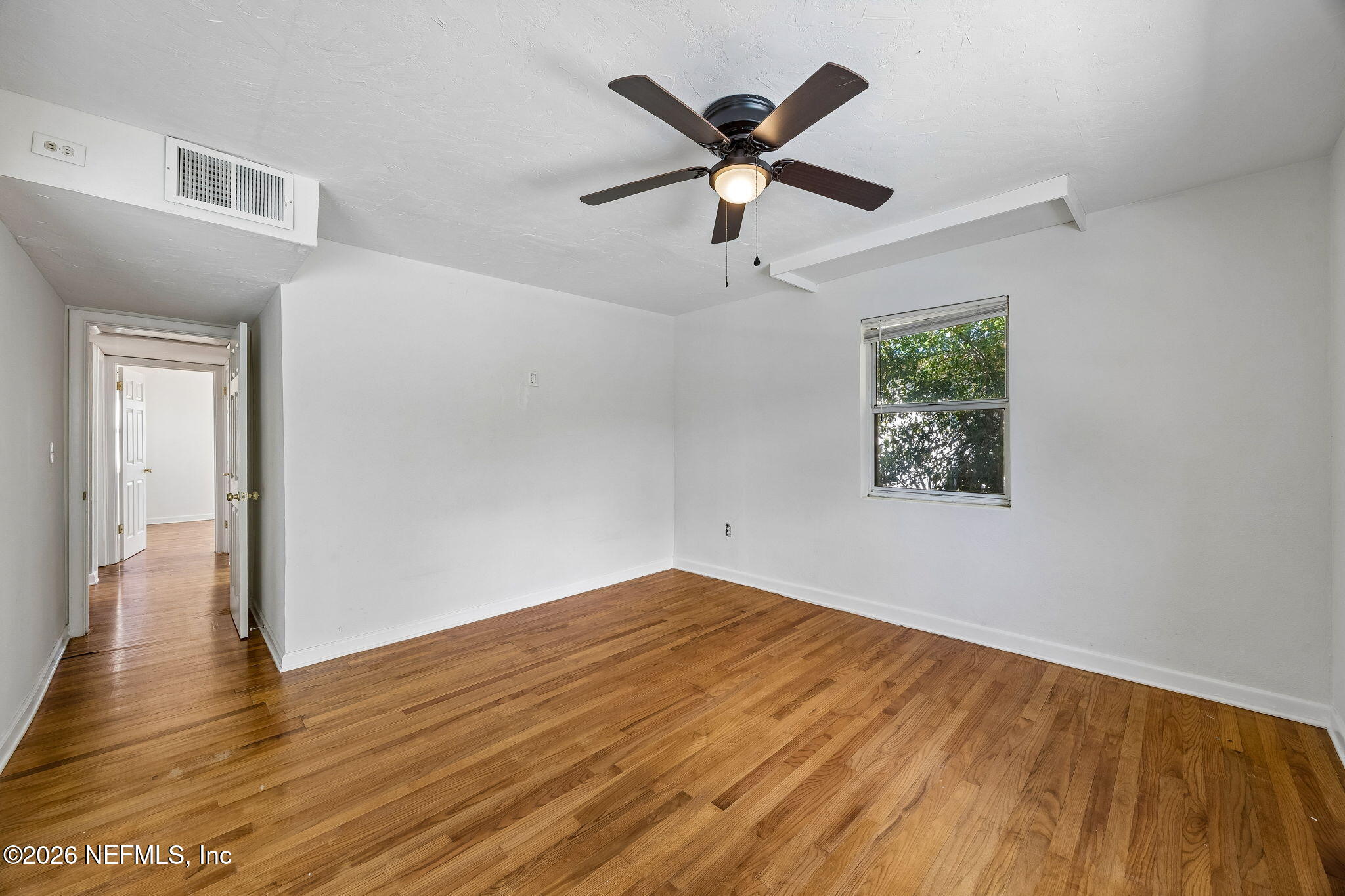 3647 Coronado Road Jacksonville, FL 32217 - Photo 26 of 49 an empty room with wooden floor and windows