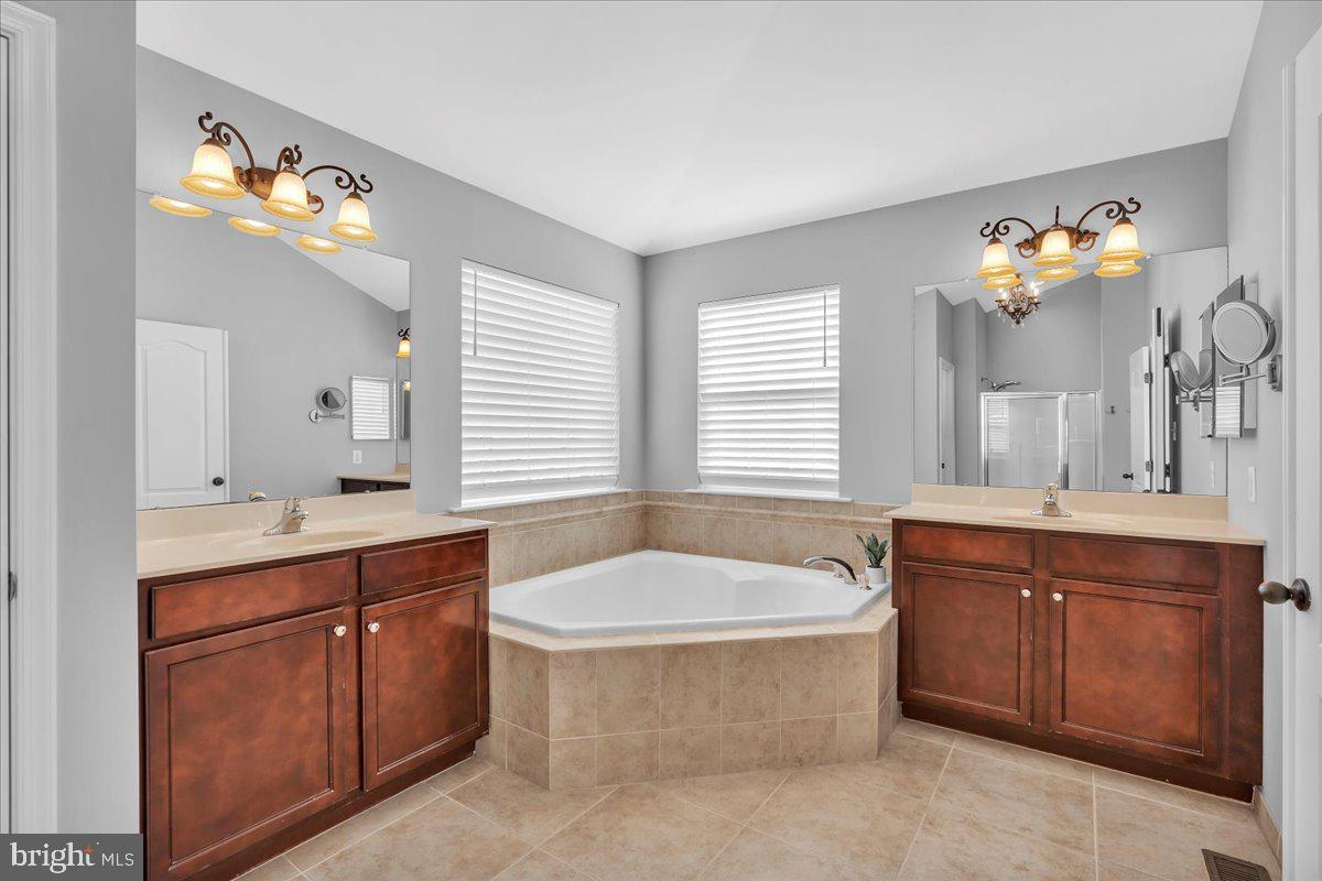 8 Elk Court Sewell, NJ 08080 - Photo 22 of 38 a spacious bathroom with a tub a double vanity sink and a large mirror