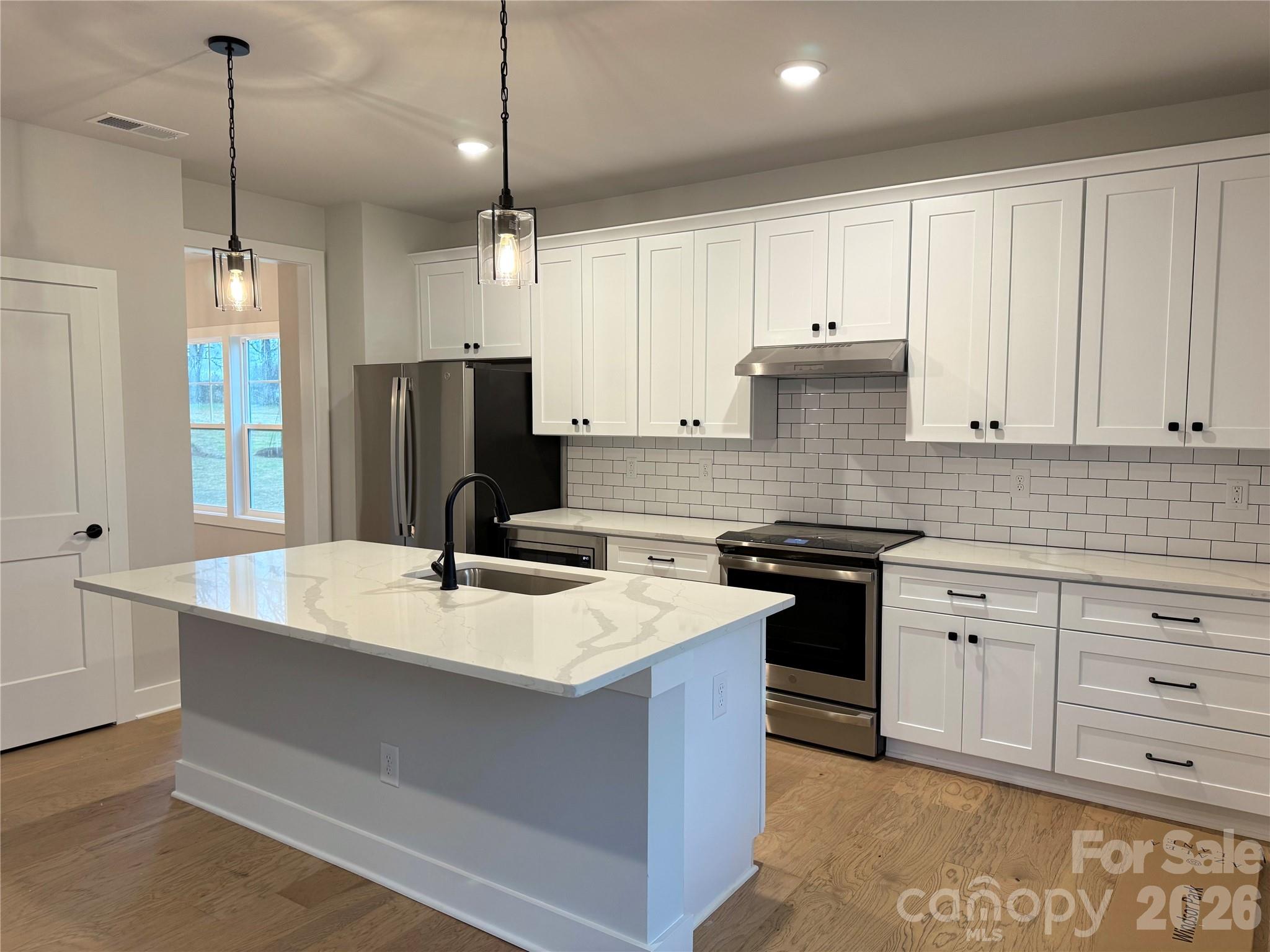 6229 King Wilkinson Road Denver, NC 28037 - Photo 3 of 13 a kitchen with a sink a stove a refrigerator and white cabinets