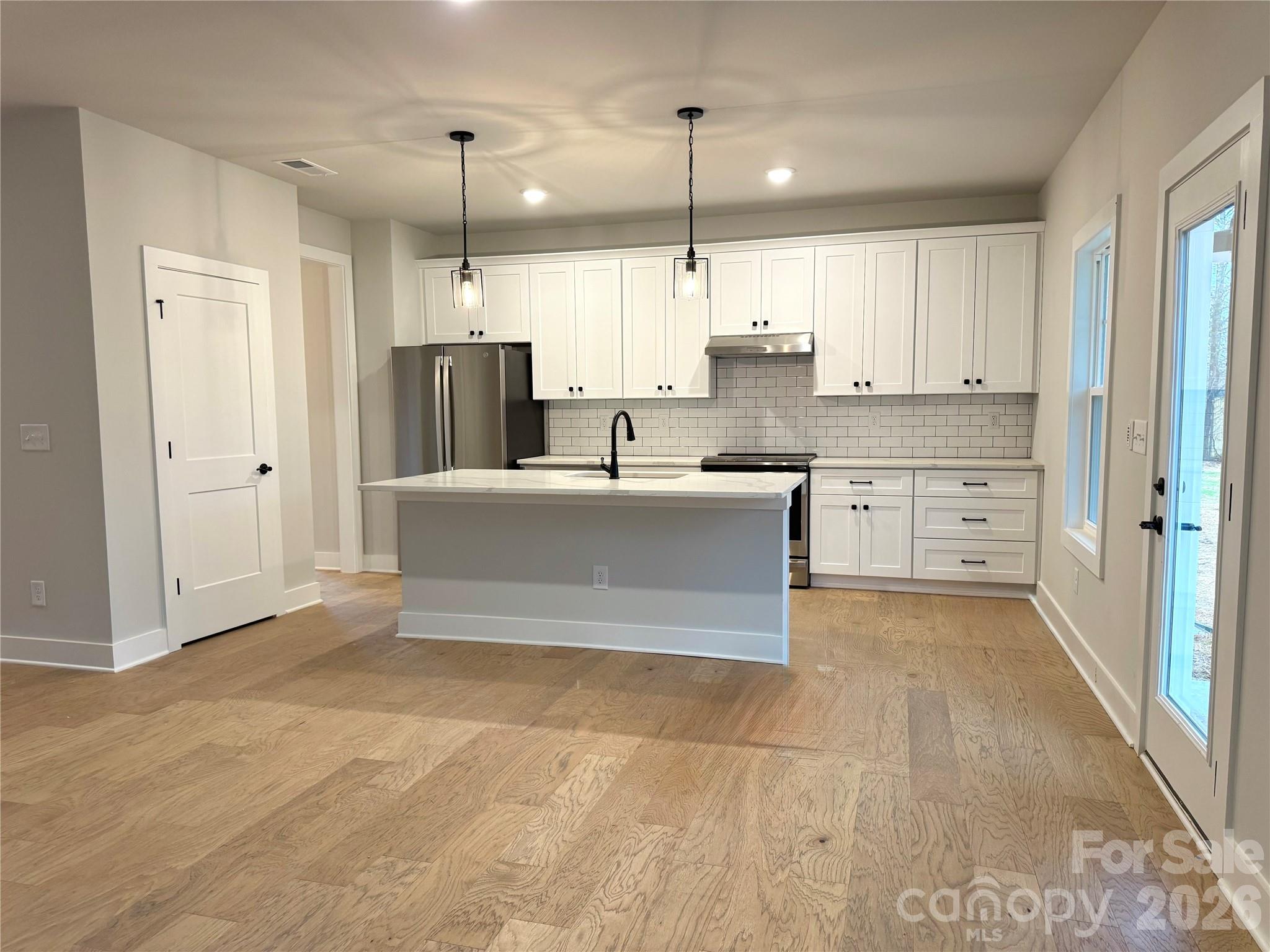 6229 King Wilkinson Road Denver, NC 28037 - Photo 4 of 13 a large kitchen with kitchen island a sink stainless steel appliances and cabinets
