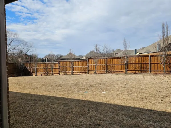 a view of a yard with wooden fence